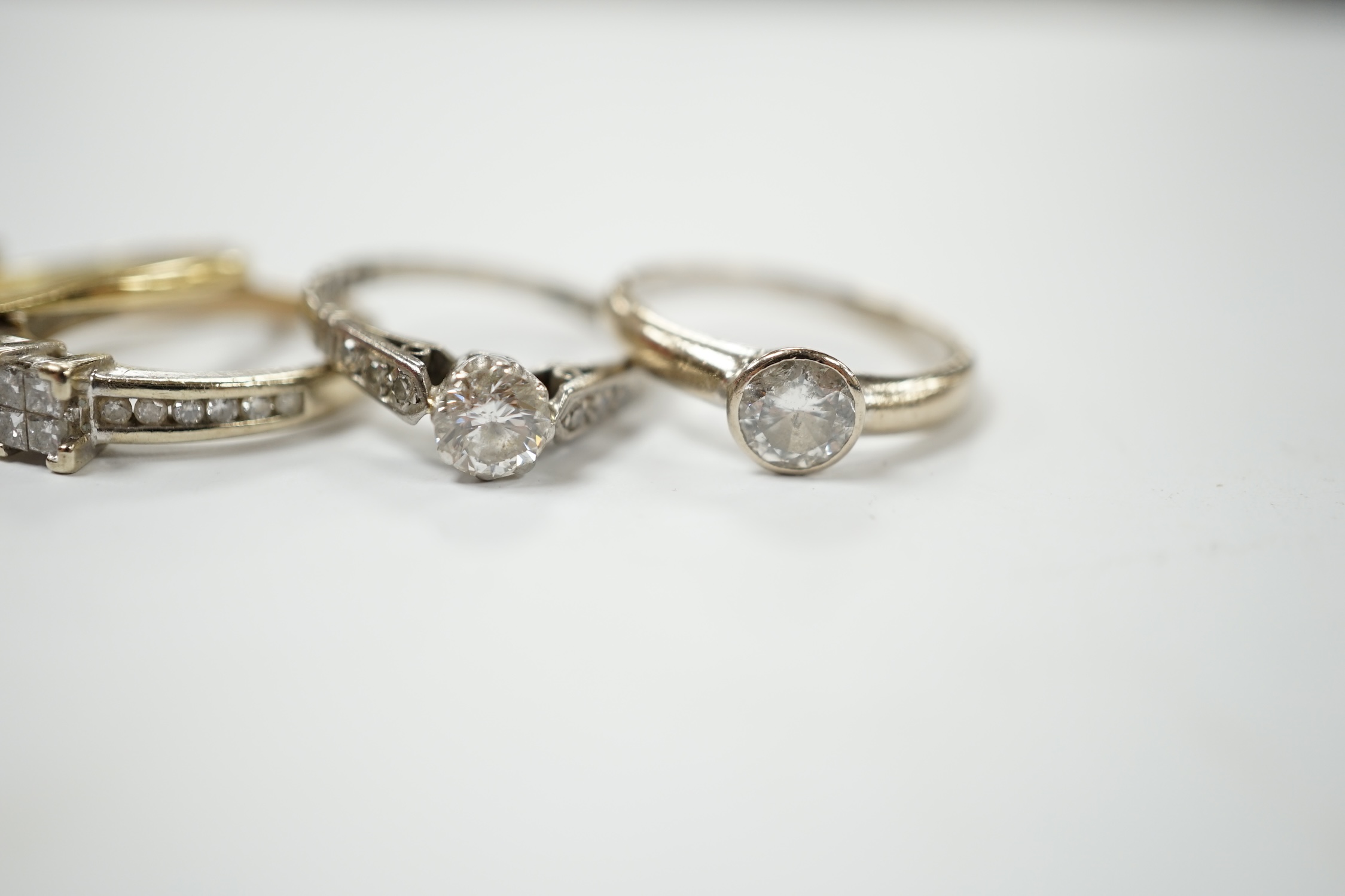 Four assorted 18ct, plat and diamond rings, including two solitaires and a flower head cluster, together with a modern 9ct and diamond cluster ring. Condition - fair